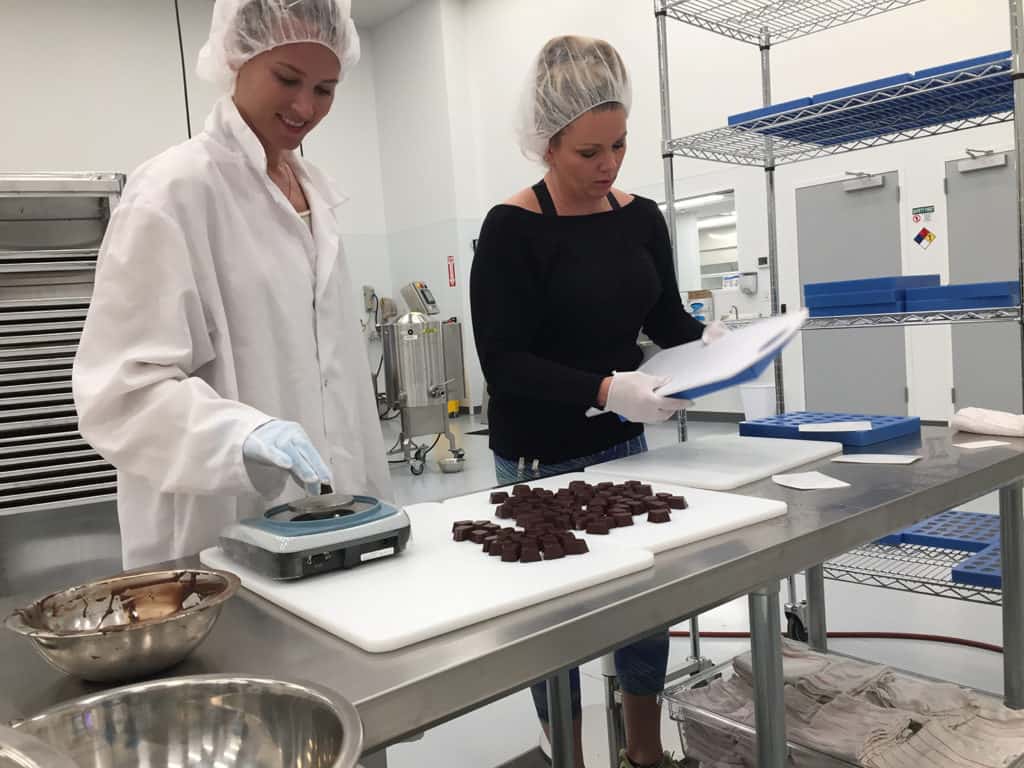 Ariel Veith and Traci Morales working on cannabis chocolates at 1906.